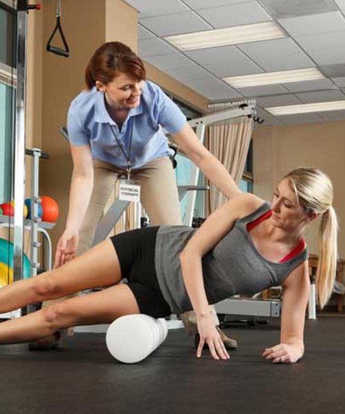 A physiotherapist guiding a woman through a strength exercise